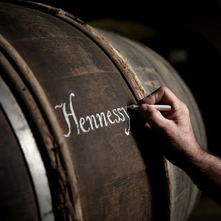 This image show someone writing Hennessy on a barrel