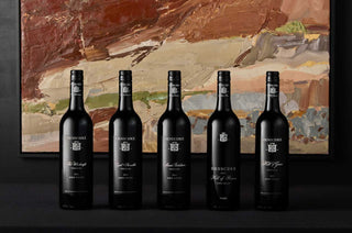 this image shows 5 bottles of henschke lined up with a beautiful brown and beige abstract painting behind it