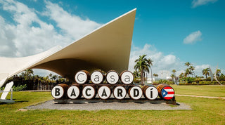 Casa Bacardi with large barrels and a modern architectural structure against a blue sky.