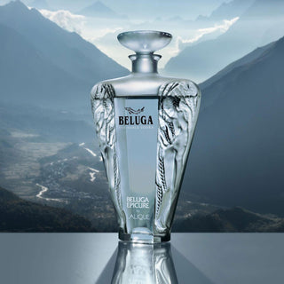 A luxurious Beluga Epicure Vodka 700ml bottle with elegant etched designs is set against a scenic mountain backdrop with misty valleys and blue skies.