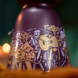 A close-up of the Clase Azul Dia de Los Muertos 2024 Música Limited Edition Tequila 1L, featuring colorful skeletons and a horned creature playing instruments, inspired by Día de los Muertos art with subtle toasted oak accents.
