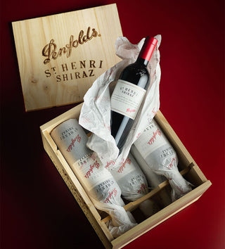 Penfolds St Henri Shiraz wine bottles in a wooden gift box on a red background