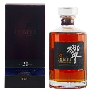 A bottle of Hibiki 21 Years Old Japanese Blended Whiskey next to its dark purple and black packaging box, on a white background.