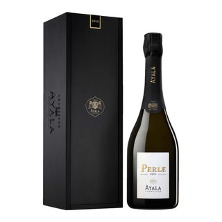A bottle of Ayala La Perle 2015 champagne stands beside its tall, elegant black box with gold accents and the Ayala logo. The bottle features a black foil top and white label, suggesting chalky minerality and citrus zest notes inside.