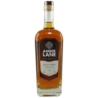 A clear glass bottle of Amber Lane Equinox Australian Single Malt Whisky features a wooden cap and dark brown label with brand details. The amber spirit inside offers rich notes of creamy vanilla fudge.