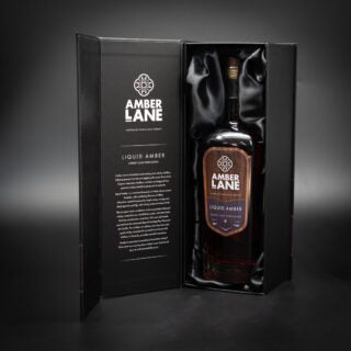 Amber Lane Liquid Amber Australian Single Malt Whisky comes in a black satin-lined gift box with brand details inside. Enjoy notes of ripe fruits and chocolate-coated dried fruits, matching its elegant presentation.