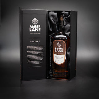 A large bottle of Amber Lane Equinox Australian Single Malt Whisky stands upright in an open, elegant black box with a silky lined interior and product details printed inside—evoking creamy vanilla fudge notes.