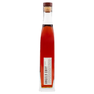 A tall, slender glass bottle with a cork stopper contains amber Angel’s Envy Kentucky Straight Bourbon Whiskey, offering hints of vanilla and dark cherries. The bottle stands upright against a plain white background.