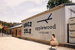 Unico Zelo and Applewood Distillery building with a person walking by.