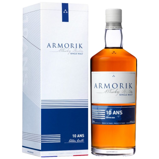 A bottle of Armorik 10 Ans (10 Year Old) French Single Malt Whisky stands beside its matching white and blue box, both labeled “10 ANS” and “Armorik Whisky Breton Single Malt,” evoking hints of honey and orchard fruits.