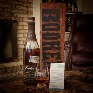 Booke bottle and glass with a wooden sign in a cozy room setting