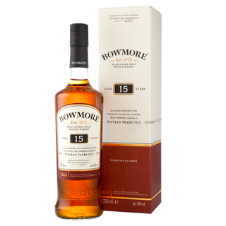 A bottle of Bowmore 15 Year Old Single Malt Scotch Whisky stands before its cream and brown box, both showcasing the brand and age statement, hinting at sherry richness and subtle peat smoke.