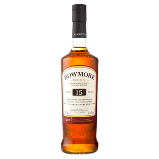 A bottle of Bowmore 15 Year Old Single Malt Scotch Whisky features a dark cap, cream label with brand and age, and amber liquid inside offering sherry richness and subtle peat smoke.