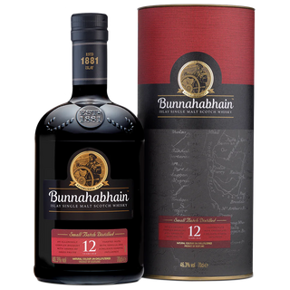 A bottle of Bunnahabhain 12 Year Old Single Malt Scotch Whisky is placed beside its cylindrical box. Both feature black, gold, and red labels with a sailor logo, emphasizing the whisky’s nutty sweetness and clear age statement.