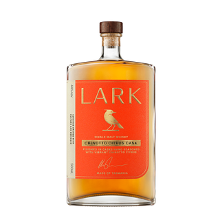A bottle of Lark Chinotto Cask Release Tasmanian Single Malt Whisky, with an orange label adorned by a bird and gold text. The amber spirit offers citrus and vanilla notes and comes sealed with a cork stopper.