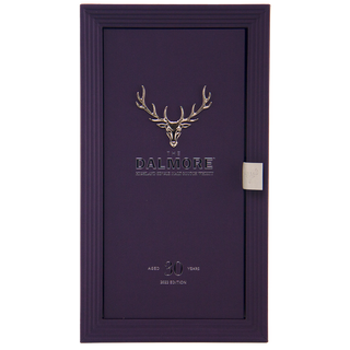 A rectangular dark purple box, reminiscent of dark chocolate, features a silver stag head and "The Dalmore 30 Year Old Single Malt Scotch Whisky, 2022 edition," with a small silver tab on the right side.