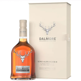 A bottle of The Dalmore King Alexander III Highland Single Malt Scotch Whisky stands before its cream box, both adorned with a silver stag logo and stylish branding—suggesting hints of red berry fruits and creamy caramel inside.
