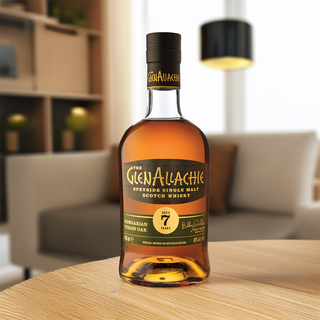 A bottle of GlenAllachie 7 Year Old Hungarian Oak Single Malt Scotch Whisky sits on a wooden table in a modern, softly-lit living room, its rich notes of honey and dark chocolate promising a cozy evening.