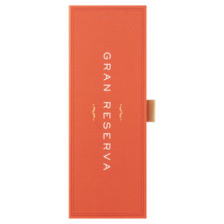 An orange-red rectangular box for Glenfiddich 21 Year Old Gran Reserva Single Malt Scotch Whisky features "GRAN RESERVA" in bold white letters on the front, suggesting spiced rum notes, and includes a small gold tab on the right side.