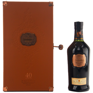 Clenched bottle of Glenfiddich whisky with a brown leather box on a white background
