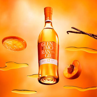 A bottle of Glenmorangie The Original 12 Year Old Single Malt Scotch Whisky floats on an orange background, surrounded by sliced peach, vanilla pod, honey drizzles, and splashes, evoking fruity smoothness with hints of vanilla and honey.