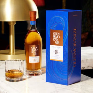 Glenmorangie 18-year-old whisky bottle and box on a table with a glass of whisky.