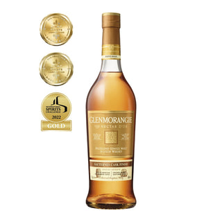 A bottle of Glenmorangie Nectar D’or Sauternes Cask Finish Single Malt Scotch Whisky is displayed beside three gold award medals, showcasing its acclaimed Sauternes cask richness and a 2022 Spirits Challenge gold medal.