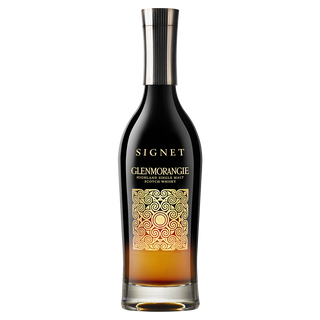A bottle of Glenmorangie Signet Single Malt Scotch Whisky with a dark amber gradient and ornate gold swirl label, hinting at mocha and dark chocolate notes, displayed on a plain white background.