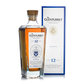 A bottle of Glenturret 12 Year Old Single Malt Scotch Whisky with a wooden cap is displayed before its white and blue box, both showcasing the brand’s logo and crest—offering notes of vanilla and oak spice.