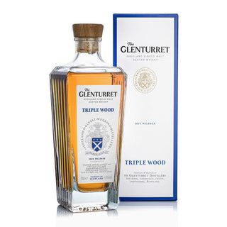A bottle of Glenturret Triple Wood Single Malt Scotch Whisky stands beside its blue and white box, featuring the brand crest and details, with notes of dried fruits and toasted oak enhancing its unique character.