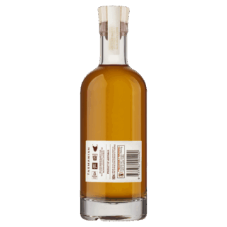 A clear glass bottle of Hellyers Road The Journeyman Single Malt Tasmanian Whisky, viewed from the back, reveals a white label with text, icons, and a barcode. It features a cork stopper and offers an enticing oak spice finish.