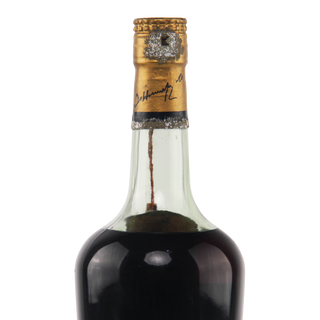 Bottle of dark liquid with a gold cork on a white background