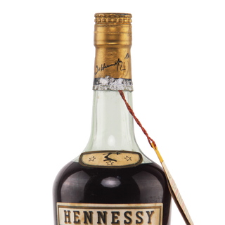 Hennessy cognac bottle with a gold cap on a white background