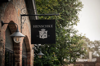 Henschke wine cellar sign on a brick building with trees in the background