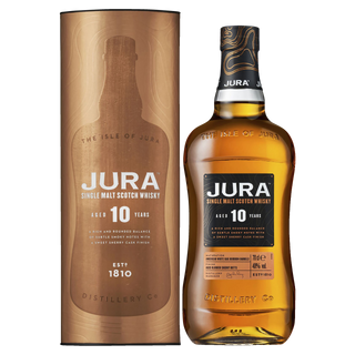 A bottle of Jura 10 Year Old Single Malt Scotch Whisky sits beside its cylindrical packaging, both displaying gold and black labels with branding and details, evoking hints of dark chocolate and toasted almonds.