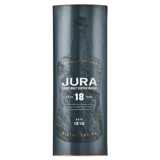 A dark blue cylindrical container for Jura 18 Year Old Single Malt Scotch Whisky features textured bottle graphics, gold lettering, and highlights its 18-year aging, notes of dark chocolate, and the distillery’s 1810 founding.