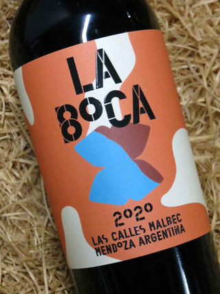 Wine bottle with 'La Boca' label on a straw background