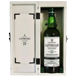 A bottle of Laphroaig 25 Year Old Single Malt Scotch Whisky 51.9% abv, famed for its rich peat smoke, stands upright in an open white wooden box featuring the brand name on the inside lid.