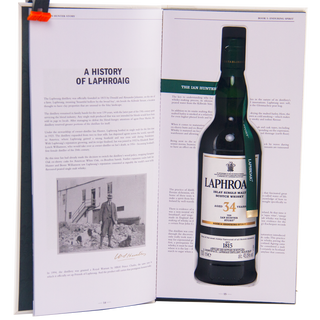 Laphroaig whiskey bottle displayed on an open book with text and images.