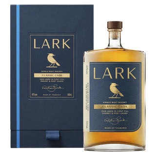 A bottle of Lark Classic Cask Tasmanian Single Malt Whisky with a blue and gold label stands before its matching box, featuring a gold bird and offering fruity malt notes with hints of red berries in its rich flavor.