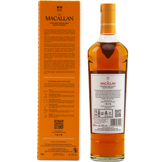 A bottle of The Macallan Colour Collection 15 Year Old Single Malt Scotch Whisky stands beside its tall orange box, both featuring detailed branding. The whisky shows a rich amber color, suggesting notes of oak and subtle vanilla custard.