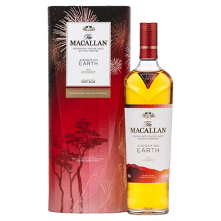 A bottle of The Macallan A Night On Earth The Journey 2023 Edition single malt whisky stands next to its festive red and black box with gold accents. The label notes flavors of toasted oak, vanilla, and citrus fruits.
