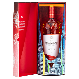 A bottle of The Macallan A Night On Earth The Journey 2023 Edition Scotch whisky is shown in an open, vibrant cityscape box with a red interior, echoing notes of toasted oak in its eye-catching presentation.