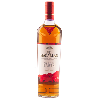 A bottle of The Macallan A Night on Earth Single Malt Scotch Whisky stands upright against a plain white background, its red and white label with gold accents hinting at notes of vanilla and baked apple.