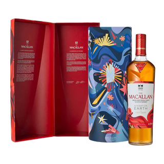 A bottle of The Macallan A Night on Earth – The First Light 2025 Release Single Malt Scotch Whisky stands beside its colorful cylindrical tin and matching open red box, featuring text and signatures inside, evoking notes of toasted oak.