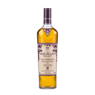 A bottle of The Macallan Harmony Collection Guardian Oak Single Malt Scotch Whisky features a purple cap and oak tree illustrations on the label, with notes of rich oak and sweet spice, set against a plain white background.