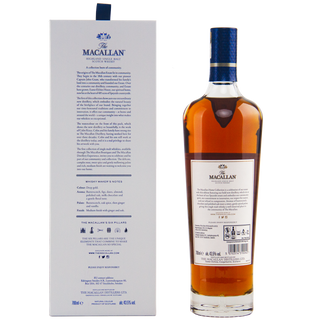 A bottle of The Macallan Home Collection The Distillery Single Malt Scotch Whisky stands upright next to its box, both featuring detailed labels. The amber whisky has a blue and white cap, all displayed against a white background.