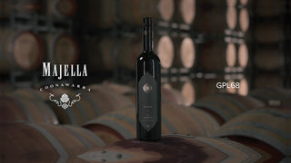 Wine bottle with 'Majella' label on barrels in a wine cellar
