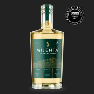 A bottle of Mijenta Tequila Reposado 700ml with a green label showing mountains and a gold bee stands against a black background. Cooked agave and vanilla notes reflect its flavor, with an award badge in the top right corner.