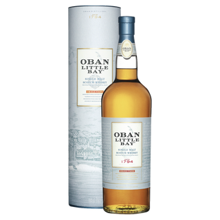 A bottle of Oban Little Bay Single Malt Scotch Whisky stands before its cylindrical packaging, both with light blue labels featuring gold and red accents and a coastal town illustration that hints at ripe fruit and subtle oak spice notes.